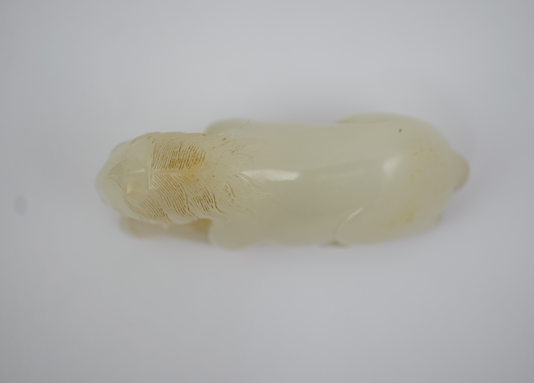 A Chinese white jade figure of a recumbent horse